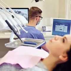 Pacjentka na fotelu dentystycznym, lekarz przy komputerze analizuje zdjęcie RTG. Czy dentysta może wystawić L4?
