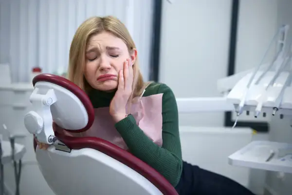 Dziewczyna w gabinecie dentystycznym cierpi z powodu silnego bólu zęba. Potrzebuje pilnej pomocy lek.